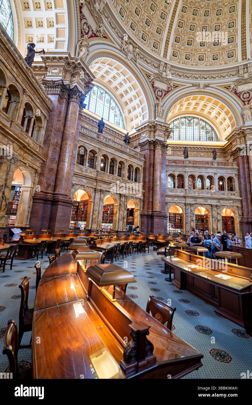 WASHINGTON DC – der Hauptlesungsraum des Thomas Jefferson Building in der Library of Congress ist einer der prächtigsten öffentlichen Räume Amerikas. Dieser achteckige Raum wurde 1897 fertiggestellt und erhebt sich 160 Meter zu einer kunstvollen Kuppel mit Edwin Howland Blashfields Gemälde „menschliches Verständnis“, umgeben von allegorischen Figuren, die Länder repräsentieren, die zum menschlichen Wissen beigetragen haben. Der Lesesaal verfügt über massive Säulen aus rotem Marmor mit vergoldeten korinthischen Kapitellen, Bronzestatuen, die Wissensfelder darstellen, und drei Reihen von Bücherstapeln, die den zentralen Raum umkreisen. Entwickelt Stockfoto