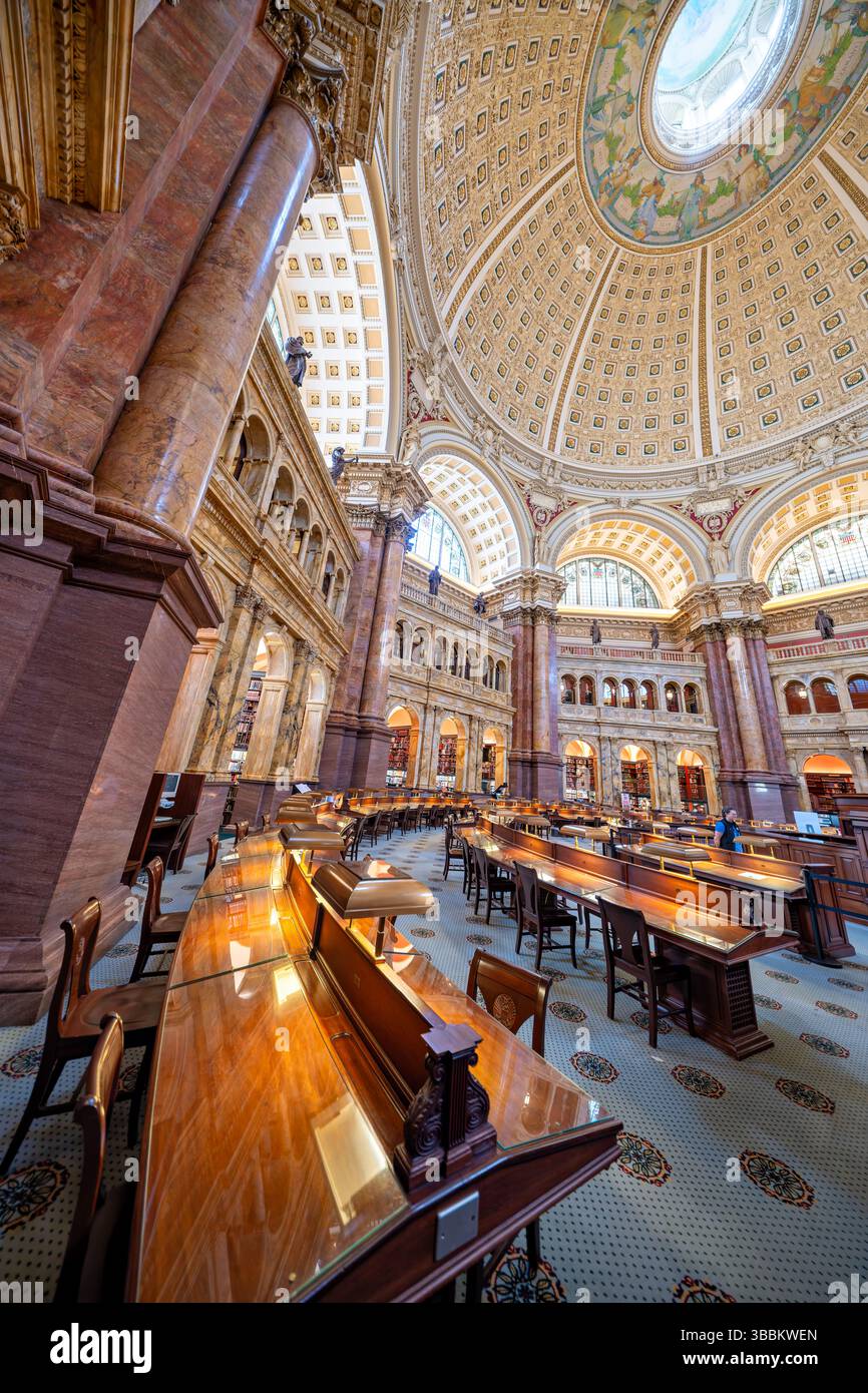 WASHINGTON DC – der Hauptlesungsraum des Thomas Jefferson Building in der Library of Congress ist einer der prächtigsten öffentlichen Räume Amerikas. Dieser achteckige Raum wurde 1897 fertiggestellt und erhebt sich 160 Meter zu einer kunstvollen Kuppel mit Edwin Howland Blashfields Gemälde „menschliches Verständnis“, umgeben von allegorischen Figuren, die Länder repräsentieren, die zum menschlichen Wissen beigetragen haben. Der Lesesaal verfügt über massive Säulen aus rotem Marmor mit vergoldeten korinthischen Kapitellen, Bronzestatuen, die Wissensfelder darstellen, und drei Reihen von Bücherstapeln, die den zentralen Raum umkreisen. Entwickelt Stockfoto