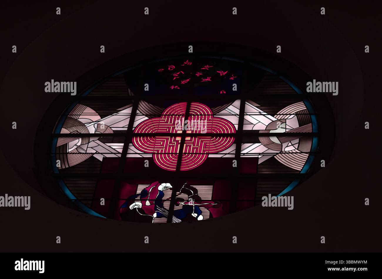 Kirchenfenster beleuchtet in Rottönen und symbolischem Design Stockfoto