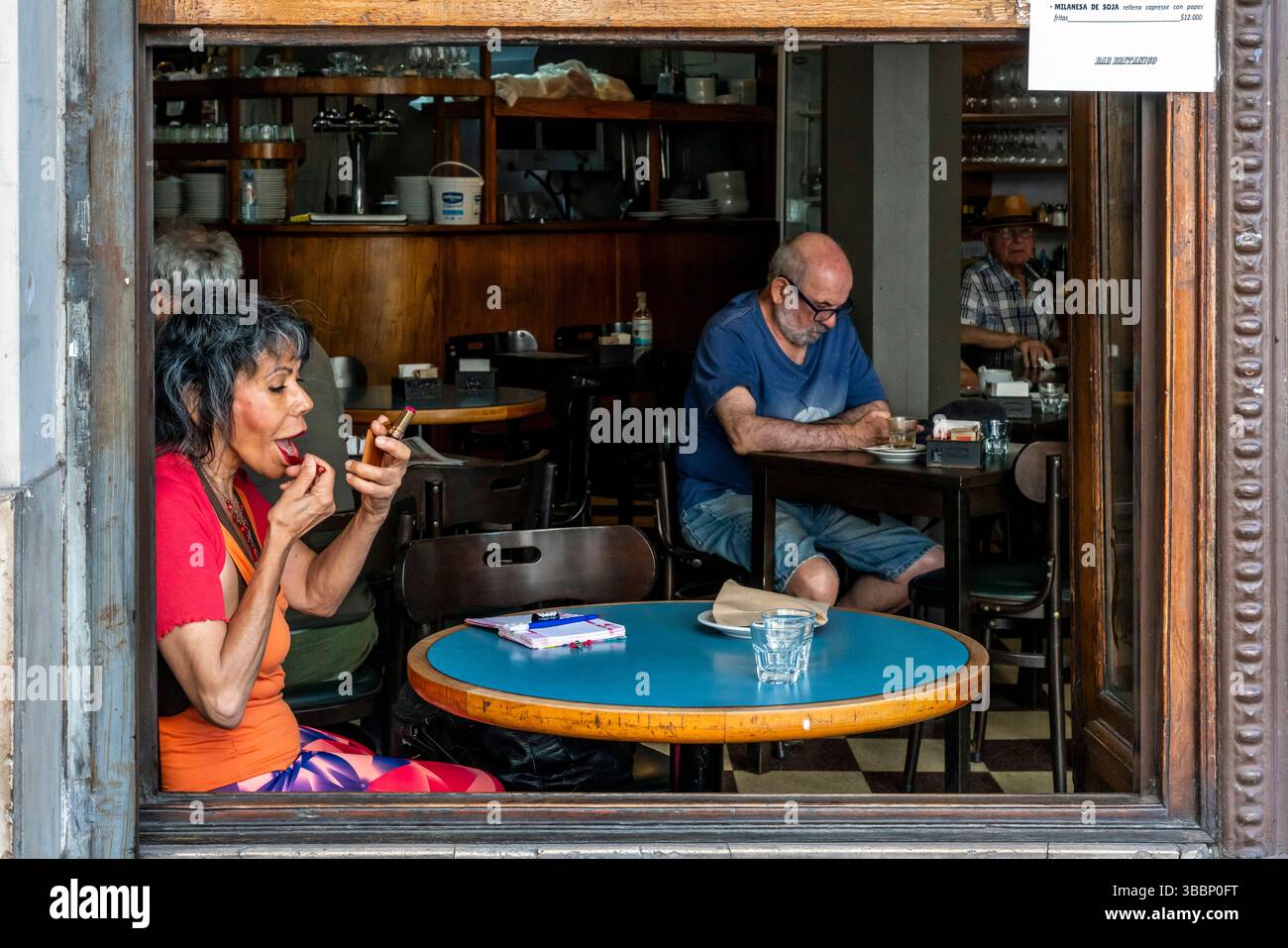 Eine Seniorin, die Make-up in der Bar Britanico, San Telmo District, Buenos Aires, Argentinien anwendet. Stockfoto Eine Seniorin, die Make-up in der Bar Britanico, San Telmo District, Buenos Aires, Argentinien anwendet. Stockfoto