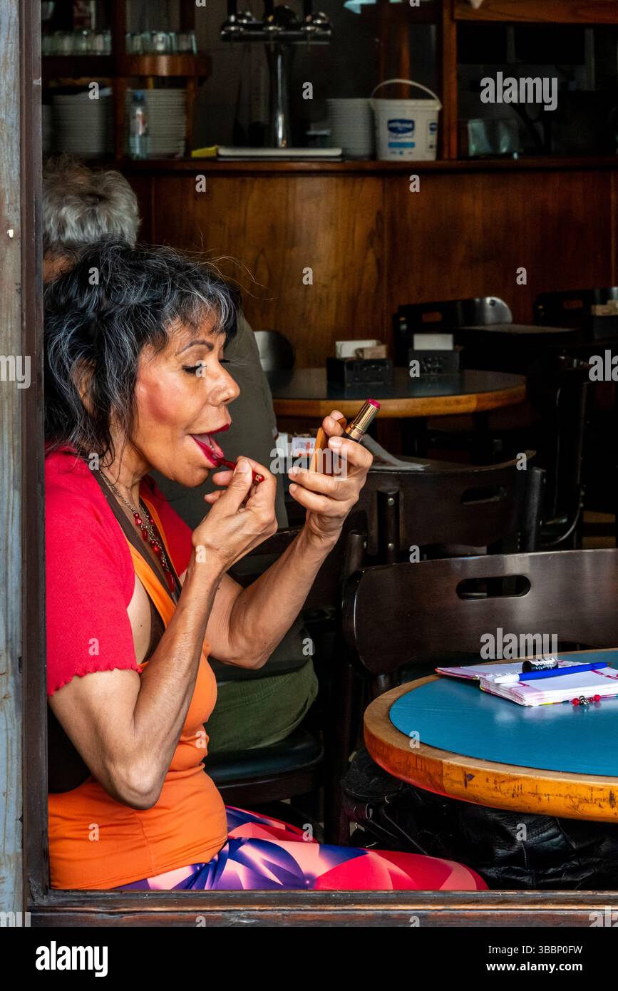 Eine Seniorin, die Make-up in der Bar Britanico, San Telmo District, Buenos Aires, Argentinien anwendet. Stockfoto Eine Seniorin, die Make-up in der Bar Britanico, San Telmo District, Buenos Aires, Argentinien anwendet. Stockfoto