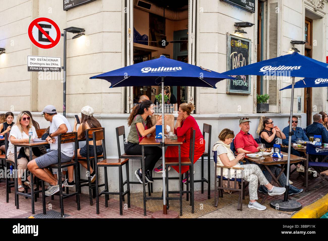Leute, die während des San Telmo Sunday Market, San Telmo District, Buenos Aires, Argentinien, vor Einem Café/Bar in der Plaza Dorrego sitzen. Stockfoto Leute, die während des San Telmo Sunday Market, San Telmo District, Buenos Aires, Argentinien, vor Einem Café/Bar in der Plaza Dorrego sitzen. Stockfoto
