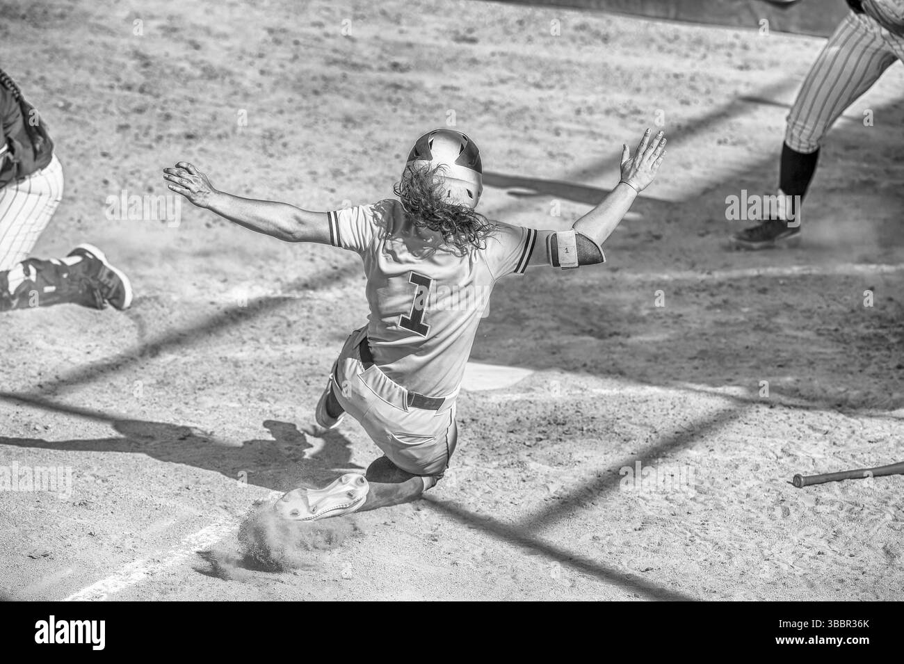 Ein Baseball-Softball-Spieler gleitet in die Kopfzeile Schwarz-weiß-Platte Stockfoto