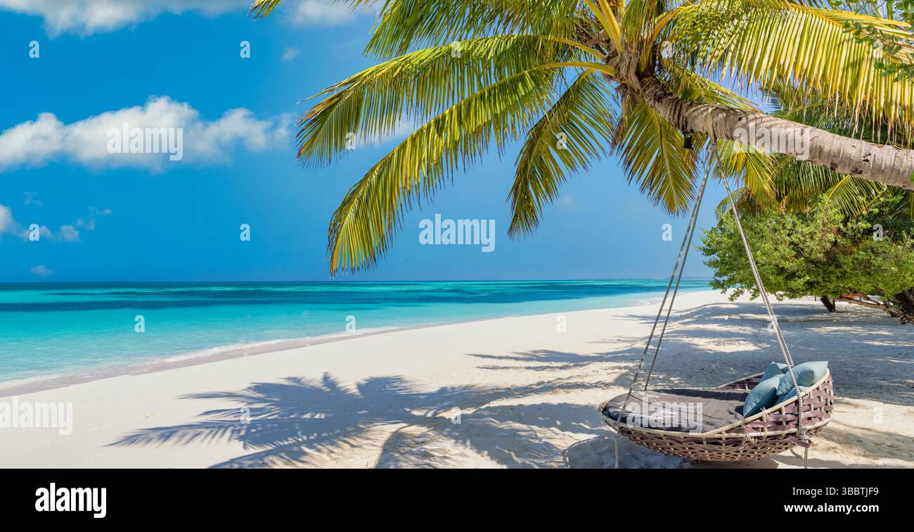 Sonniger Panoramastrand Schaukel Hängematte romantische Liebe idyllische tropische Szene mit ruhigem Meereshimmel helles warmes Sonnenlicht friedliche ruhige Urlaubsstimmung Stockfoto