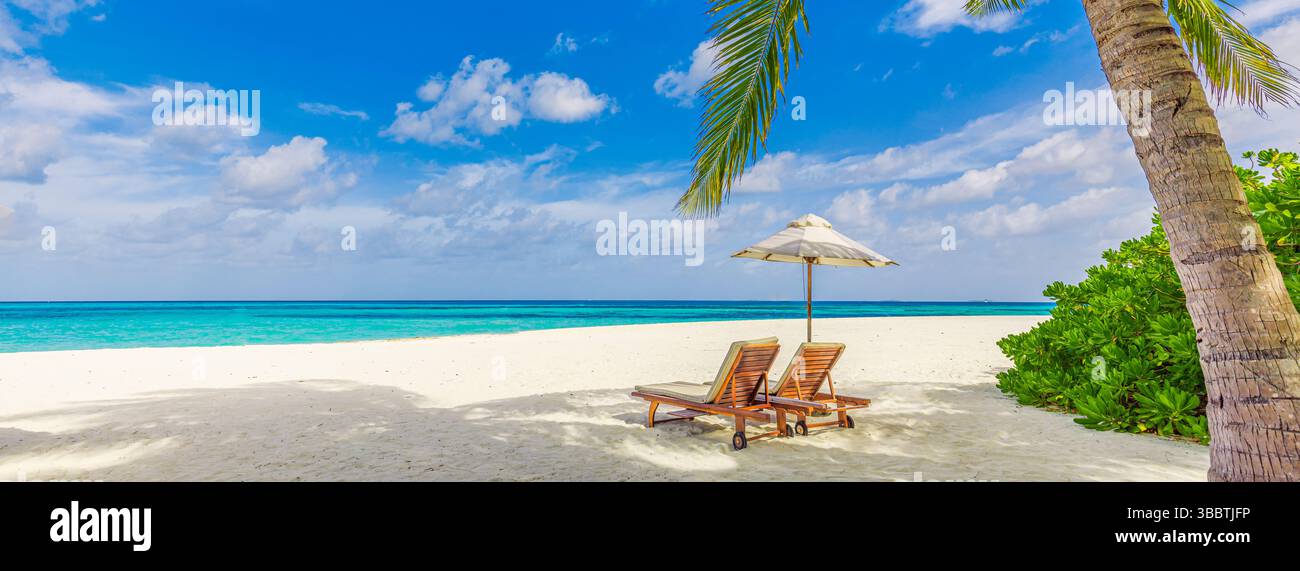 Panorama Nahaufnahme von paar Liegen Sonnenschirm Palmen Blätter auf Sandstrand mit ruhigem Meereshimmel fantastisch entspannend friedliche Natur Tapeten Hintergrund Stockfoto