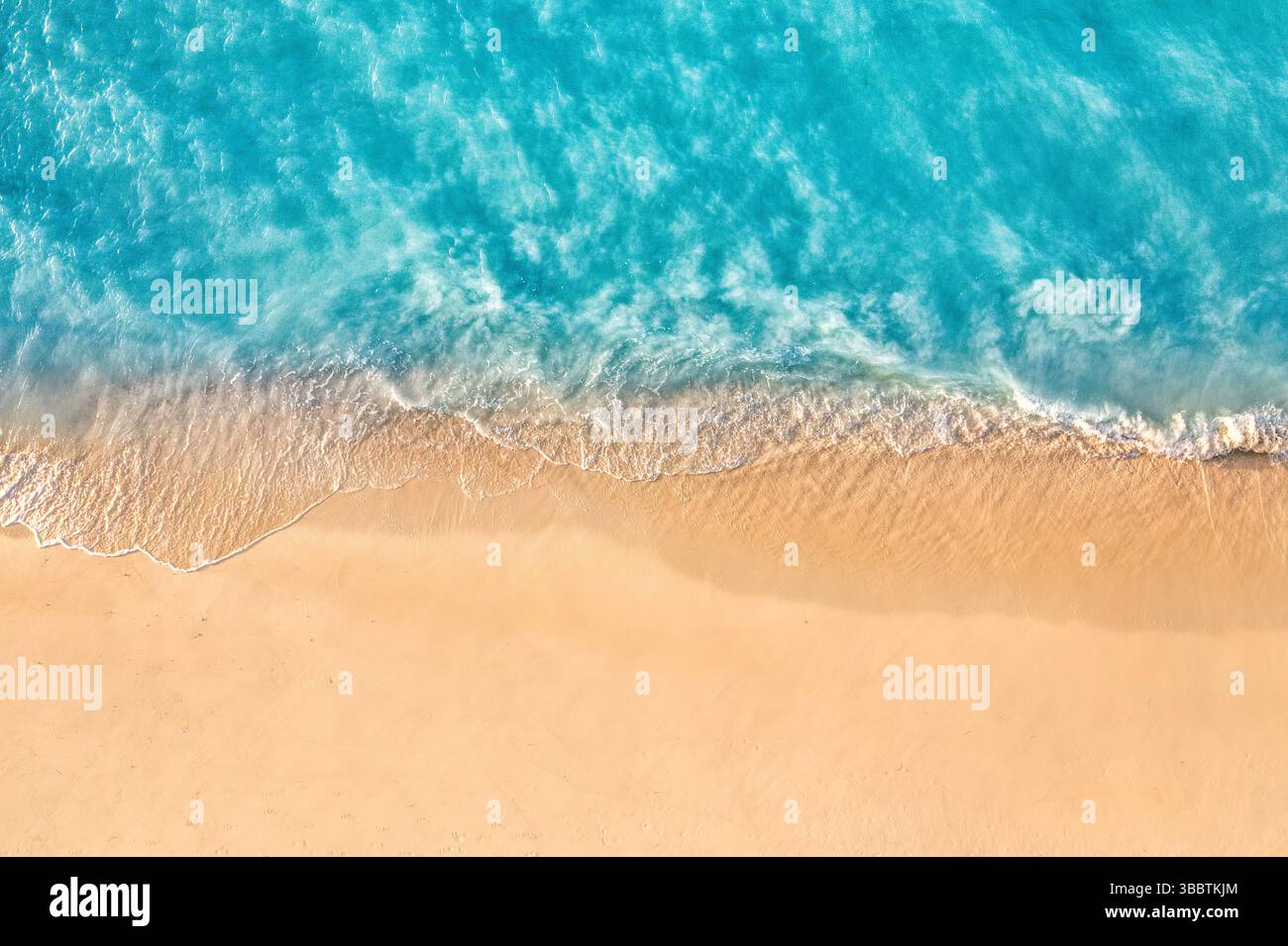 Aus der Vogelperspektive Sandstrand Küste mit ruhigen Meereswellen friedlicher Natur Hintergrund tropisches Sommermuster Textur natürliche Küste Urlaub Landschaft Stockfoto