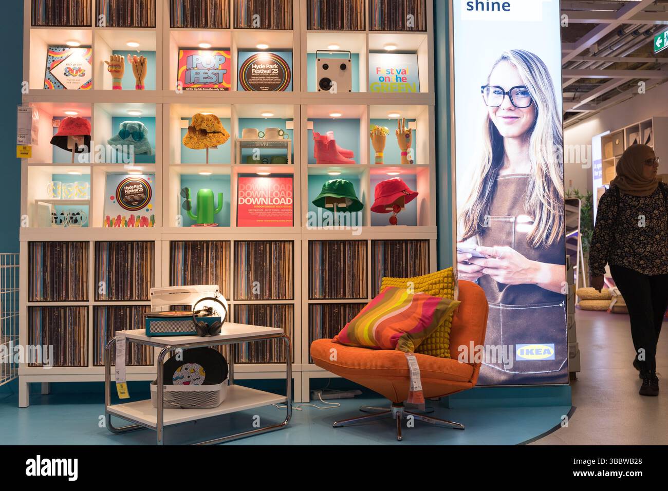 Lounge mit lebhaftem orangefarbenem Sofa und Couchtisch vor einem auffälligen Vitrinenschrank mit einzigartigen Artefakten für ein schickes Ikea Living UK Stockfoto