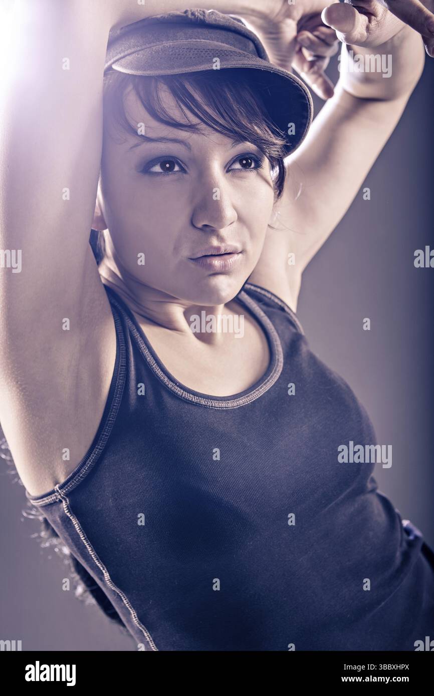 Junge Frau im Sportkleid, die in Zumba, Reggaeton oder Hiphop-Stil tanzt Stockfoto
