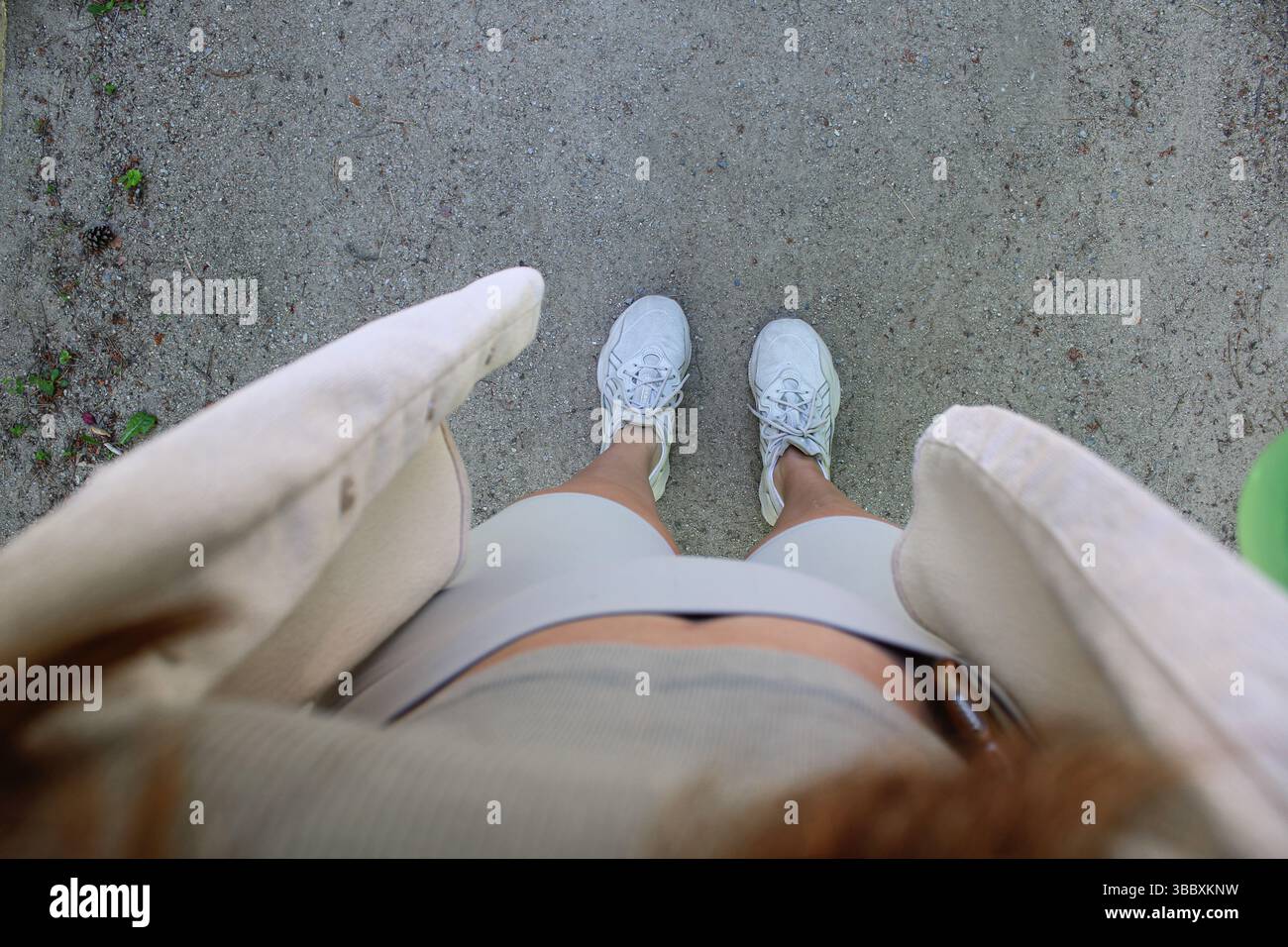 Minimalistisches Sommer-Outfit von oben – urbane Walking-Perspektive Stockfoto