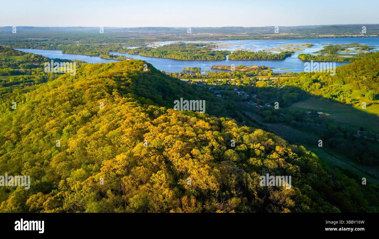Aus der Vogelperspektive vom Apple Blossom Overlook Park mit grünen sanften Hügeln und dem Mississippi River bei Sonnenuntergang mit strahlendem Himmel und friedlicher Landschaft. Stockfoto