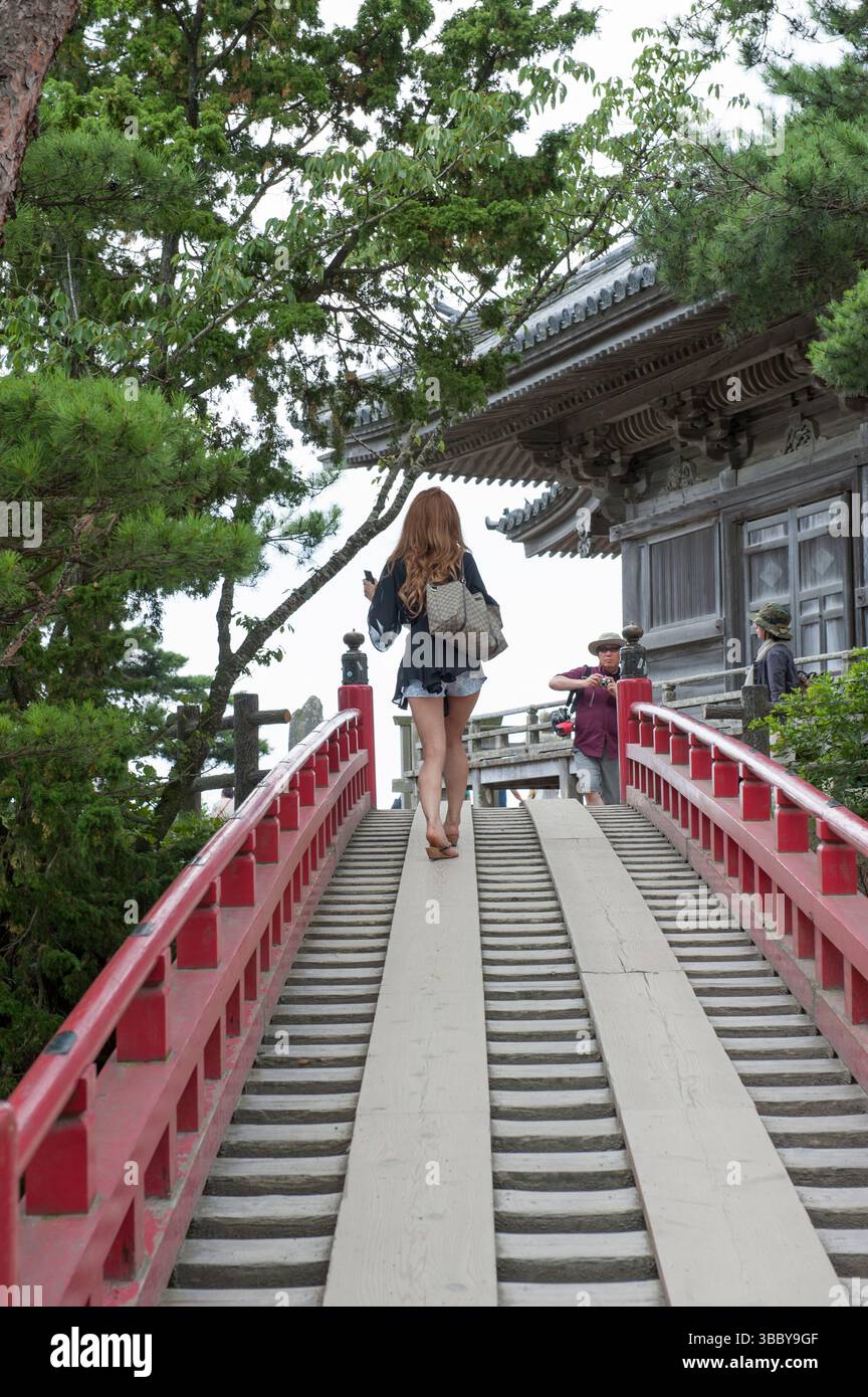 Frau, die in Japan Tempeltreppen hinaufgeht Stockfoto