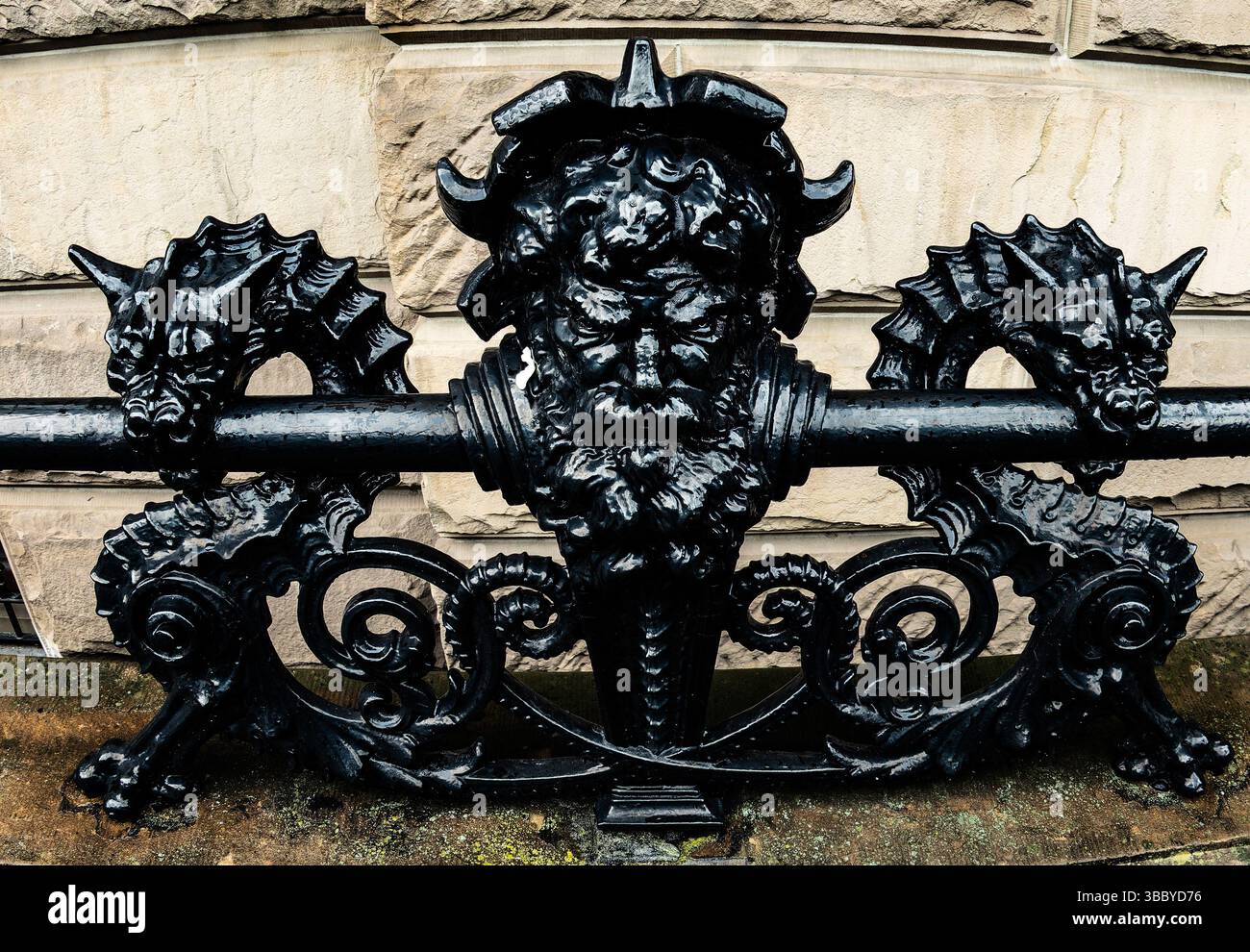 Dekorative Gargoyles auf einem glänzenden schwarzen Zaun Stockfoto