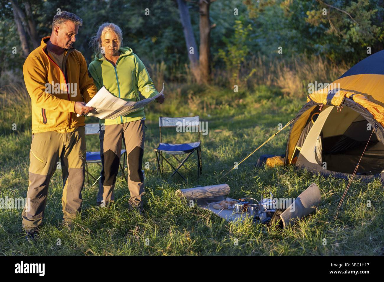 Paare planen ihr Outdoor-Abenteuer mit Karte in der Natur Stockfoto