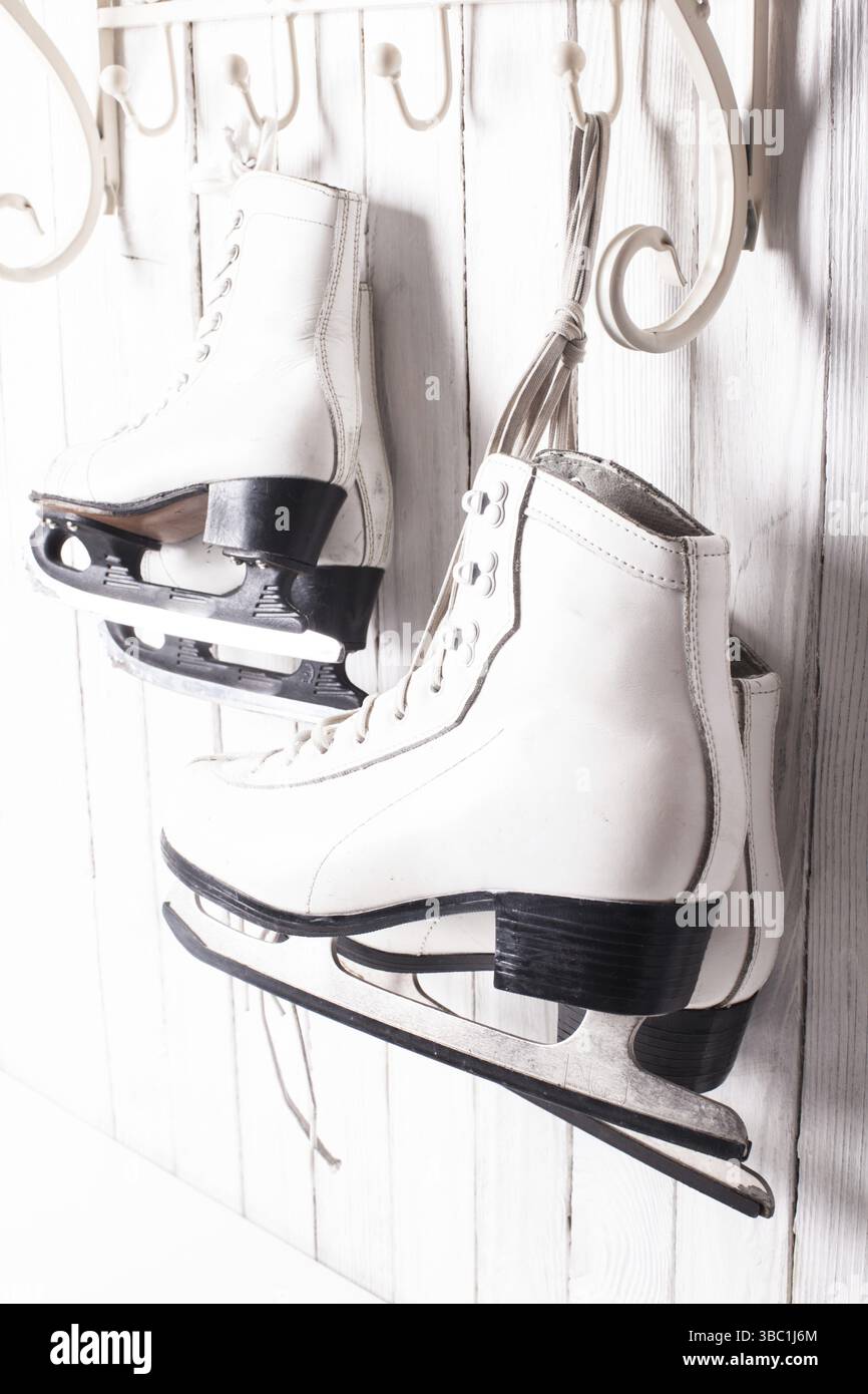 Zwei Paar Schlittschuhe, die am Haken hängen. Skating-Konzept für die ganze Familie Stockfoto