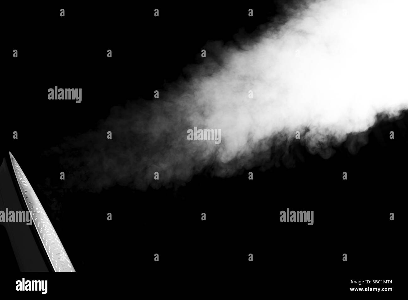 Elektrisches Bügeleisen mit Dampf isoliert auf schwarzem Hintergrund. Haushaltsgerät Stockfoto