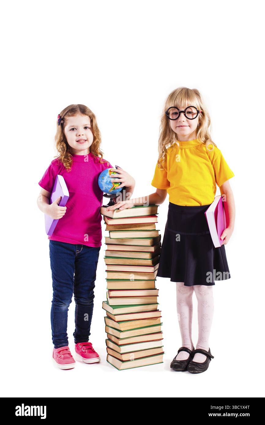 Zwei Mädchen, die in der Nähe hoher Bücher stehen. Das Konzept des Schulrückgangs Stockfoto