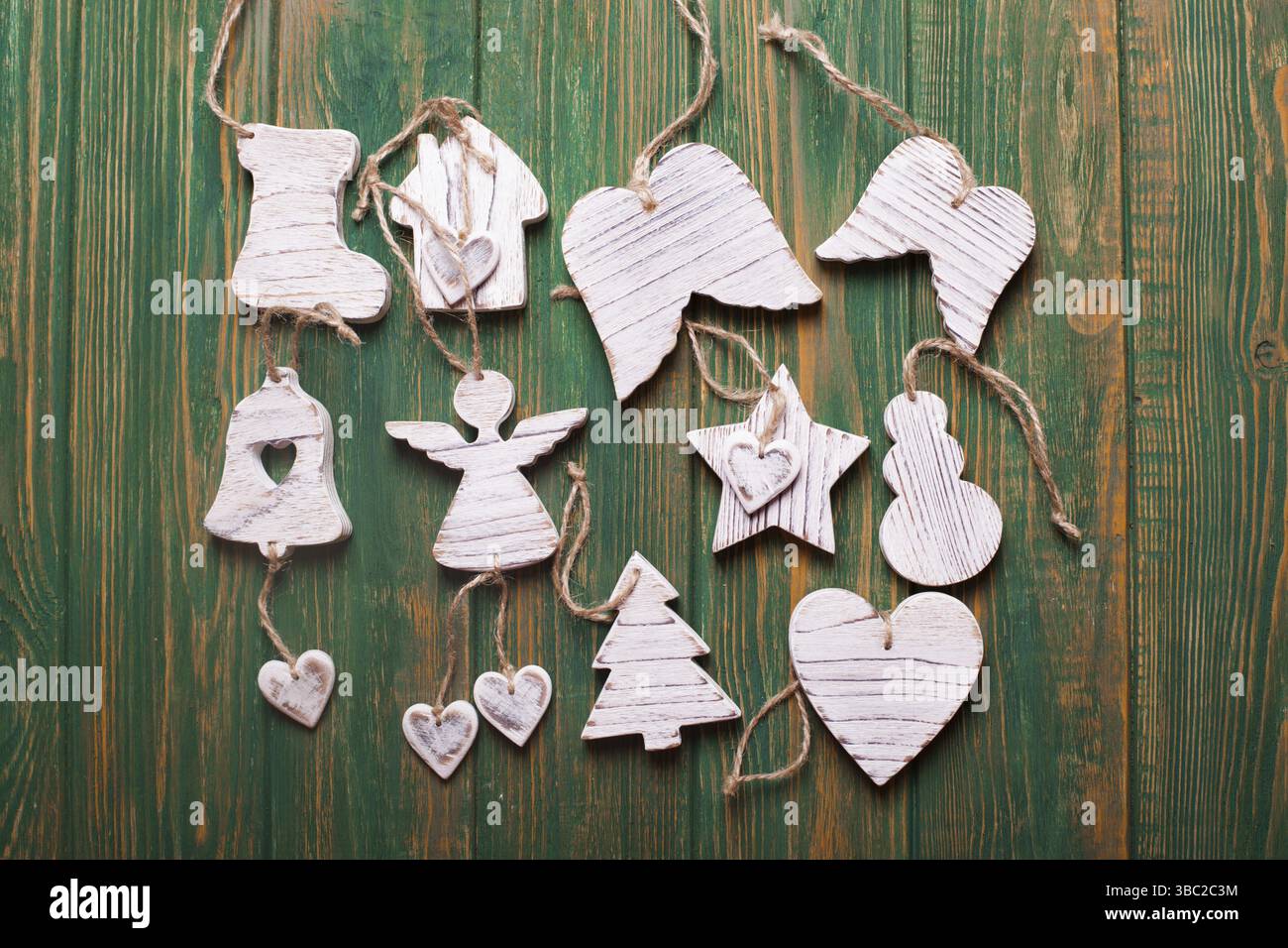 Hölzerne Weihnachtsspielzeuge, weißer, schäbiger, schicker Stil auf Grün Stockfoto