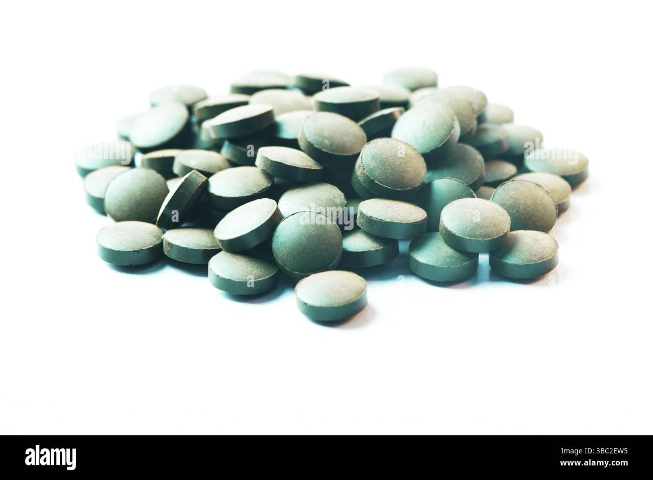 Runde Spirulina-Pillen auf weißem Hintergrund isoliert Stockfoto