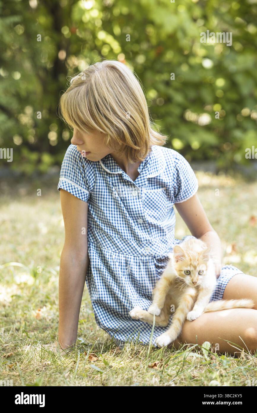 Mädchen spielen mit Kätzchen draußen im Park Stockfoto