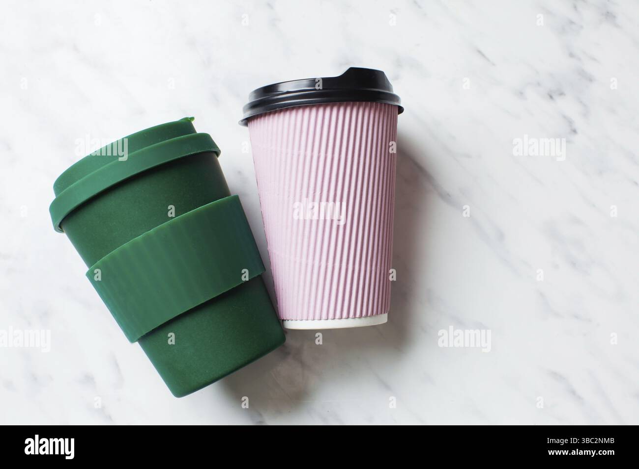 Wiederverwendbare Kaffeetasse aus Papier und Bambus auf weißem Marmorhintergrund. Umweltfreundliche Wahl Stockfoto