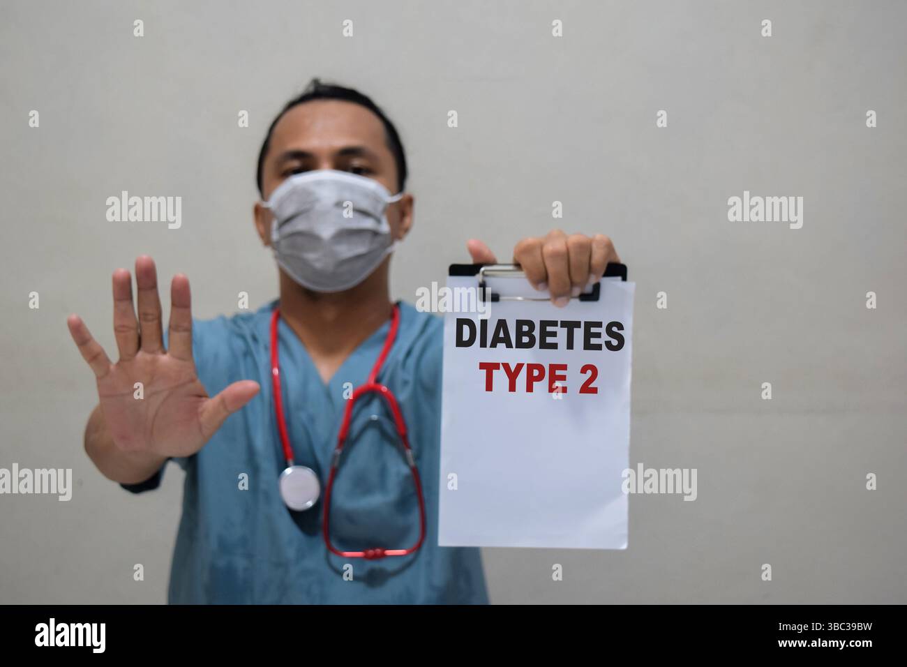 Junger Arzt mit Stop-Geste und Papier halten mit Text Diabetes Typ 2 Stockfoto