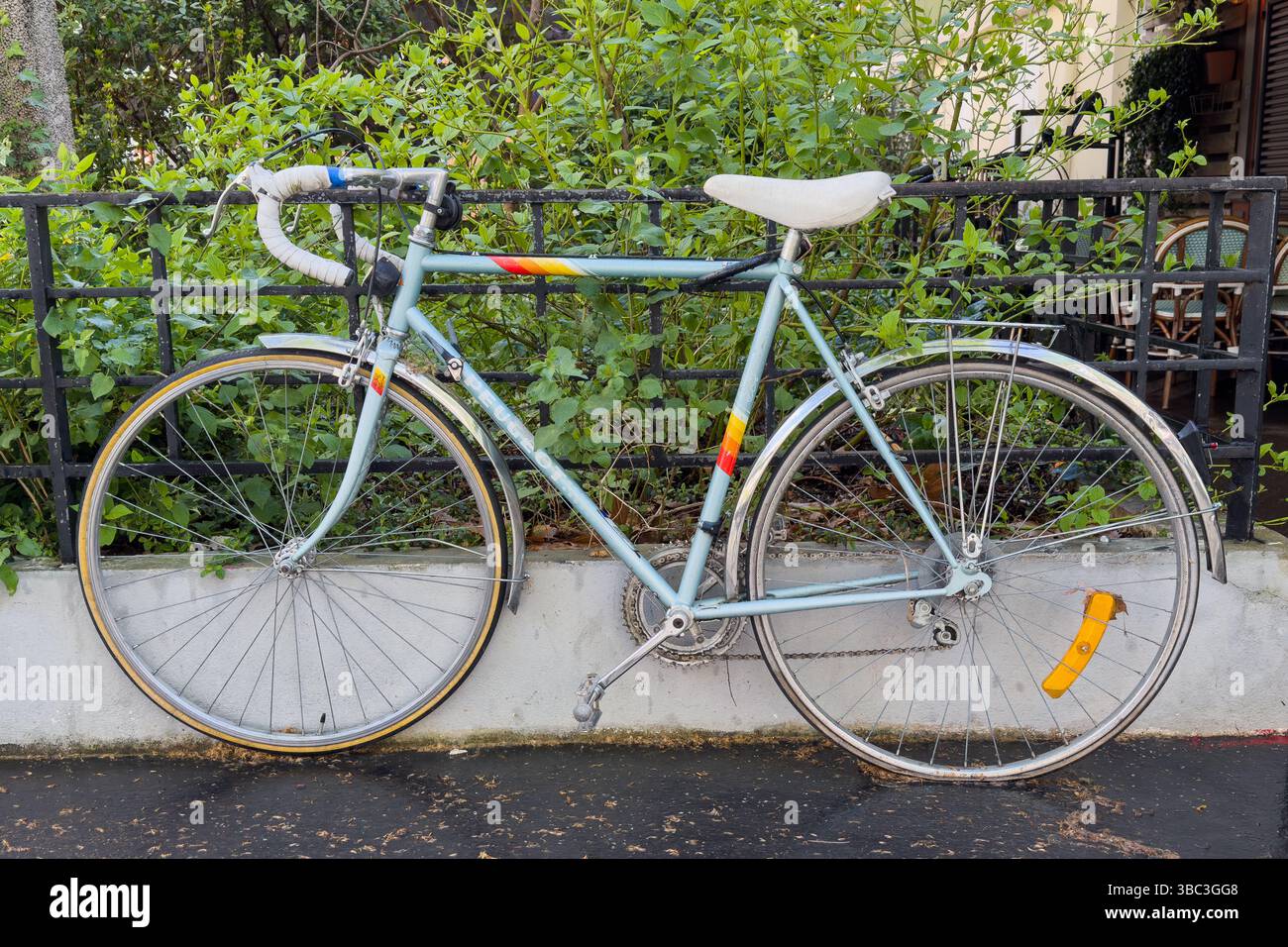 Paris, Frankreich - 16. April 2024: Klassisches Peugeot-Fahrrad wird bei Tageslicht vor grüner Kulisse in städtischer Umgebung präsentiert Stockfoto