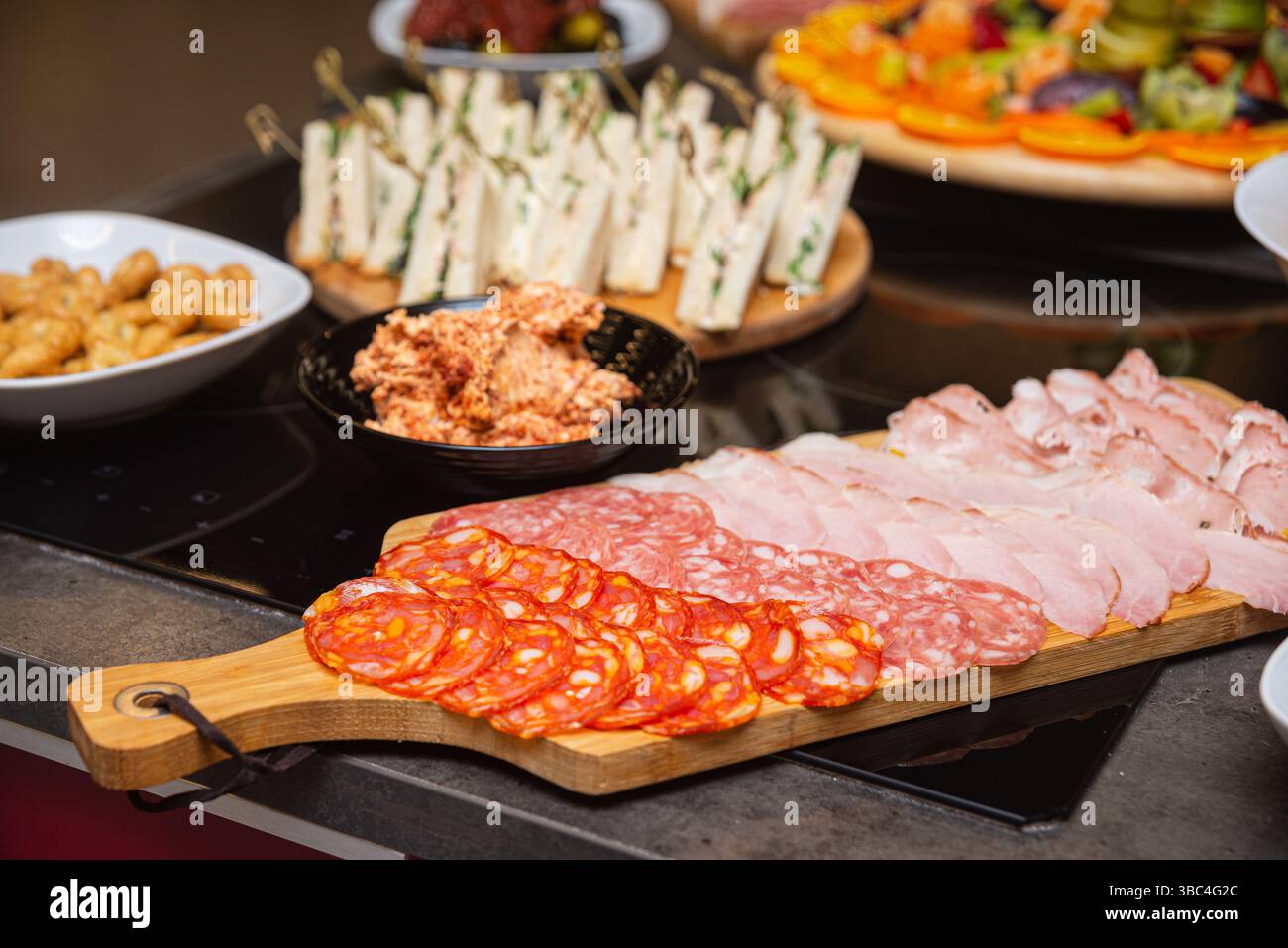 Verschiedene Aufschnitt-Wurstwaren einschließlich Salami, Chorizo und Schinken auf einem Holzbrett für ein Buffet oder eine Party. Stockfoto