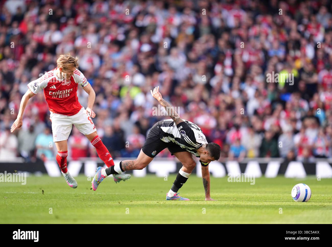 Martin Odegaard von Arsenal und Bruno Guimaraes von Newcastle United kämpfen um den Ball während des Premier League-Spiels im Emirates Stadium, London. Bilddatum: Sonntag, 18. Mai 2025. Stockfoto