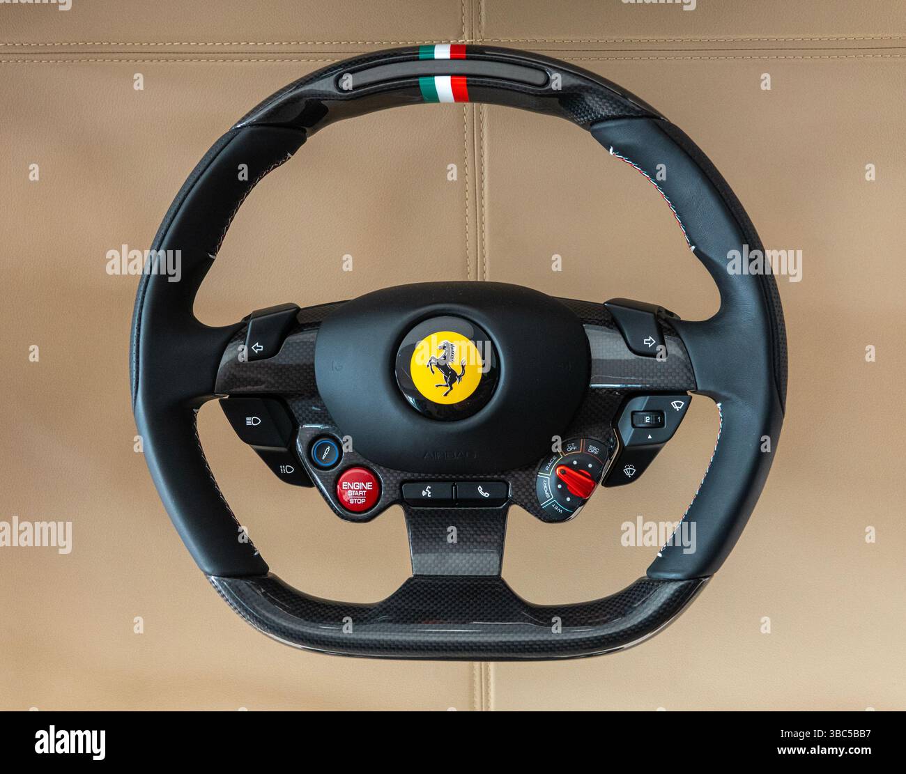 Modernes Ferrari-Lenkrad auf Lederhintergrund mit Markenlogo. Stockfoto
