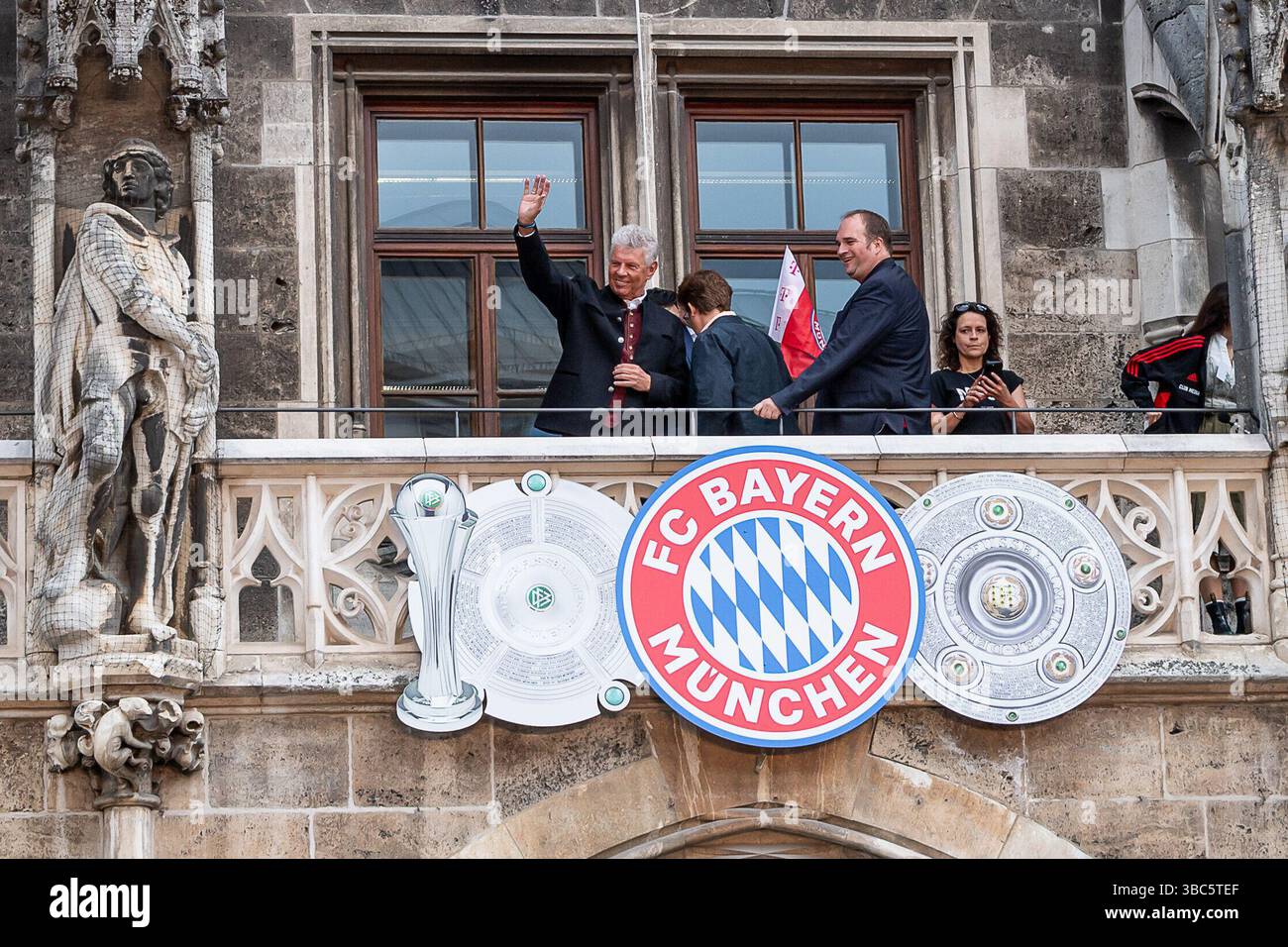 München, Deutschland. Mai 2025. Dieter Reiter (Oberbuergermeister der Stadt München) zeigt sich schon mal den Fans winkend vorab auf dem Rathausbalkon, der mit den Trophaeen und dem Logo des FC Bayern München verziert ist Empfang und Meisterehrung FC Bayern München Maenner und Frauen, Fussball, Bundesliga, Saison 2024/2025, 18.05.2025. Foto: Eibner-Pressefoto/Heike feiner Credit: dpa/Alamy Live News Stockfoto