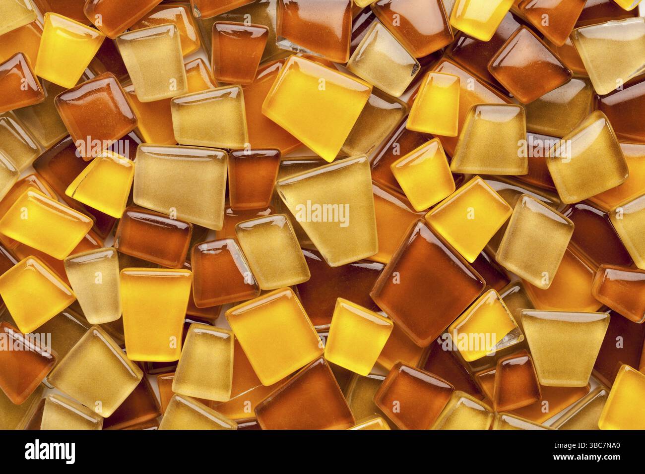 Zufälliger Hintergrund von gelben, braunen und bernsteinfarbenen Glasmosaikfliesen Stockfoto