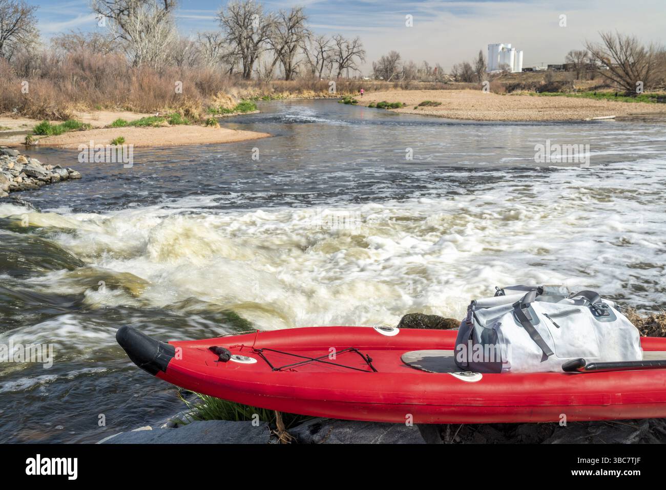 Aufblasbares Stand Up Paddleboard am Ufer des South Platte River im Norden von Colorado in der Frühjahrslandschaft Stockfoto