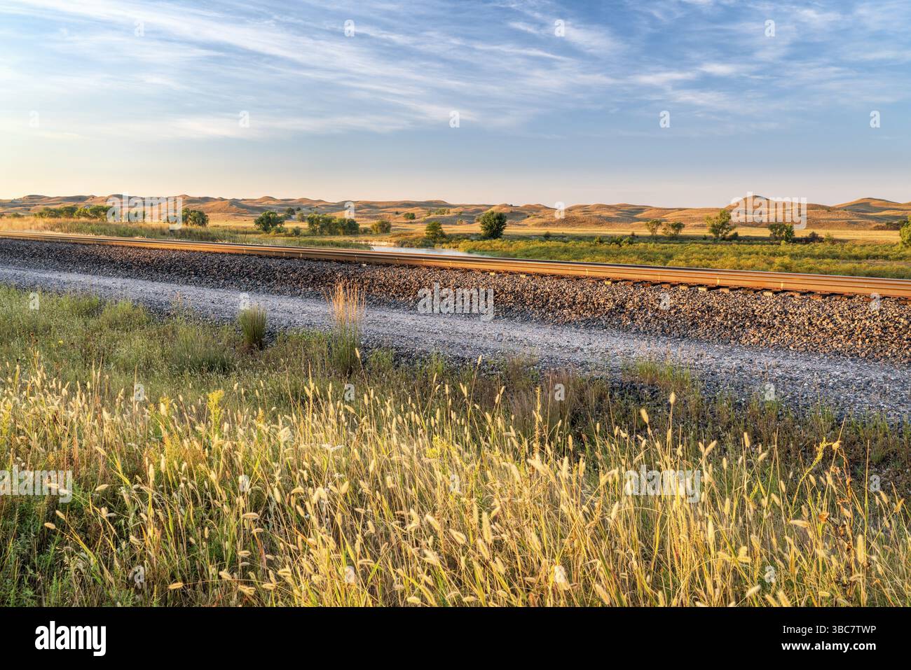 Eisenbahnschienen entlang eines Tals des Middle Loup River in Nebraska Sandhills, Spätsommerlandschaft Stockfoto