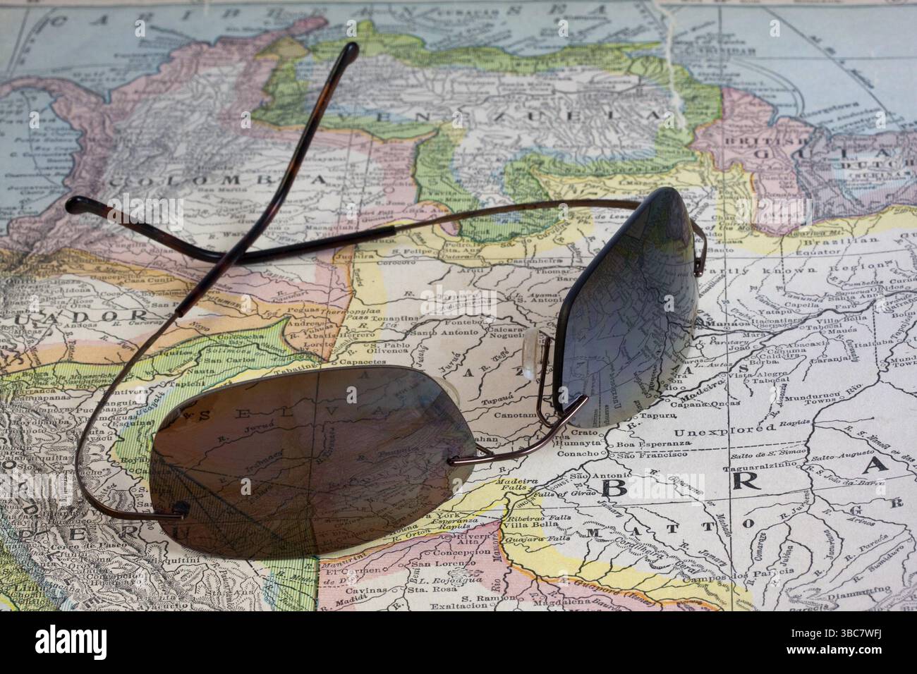 Reisekonzept - Sonnenbrille über Vintage, Warnung, 90 Jahre alte Karte von Südamerika (New International Atlas of the World, Ausgabe 1926) mit br Stockfoto