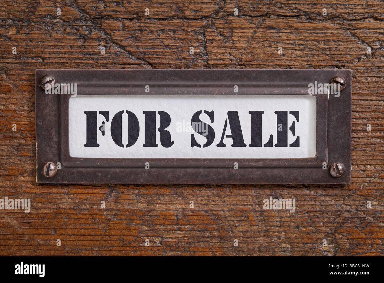 Zum Verkauf - Aktenschranketikett, Bronzehalter gegen Schmirgel und zerkratztes Holz Stockfoto