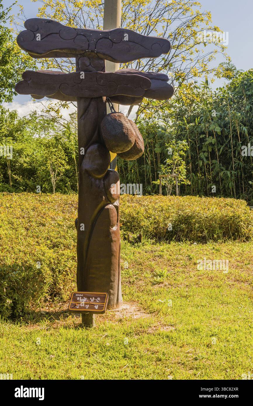Samcheok, Südkorea. 25. September 2018: Phallische Holzstatue, die dem Hodensack eines Menschen ähnelt, der vor grünem Laub am Berg steht Stockfoto Samcheok, Südkorea. 25. September 2018: Phallische Holzstatue, die dem Hodensack eines Menschen ähnelt, der vor grünem Laub am Berg steht Stockfoto