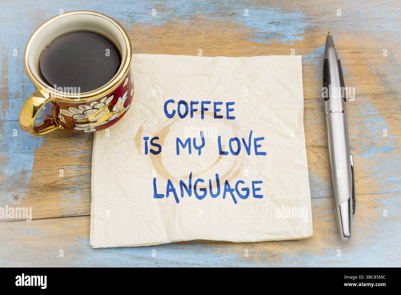 Kaffee ist meine liebe Sprache - Handschrift auf eine Serviette mit einer Tasse Kaffee Stockfoto