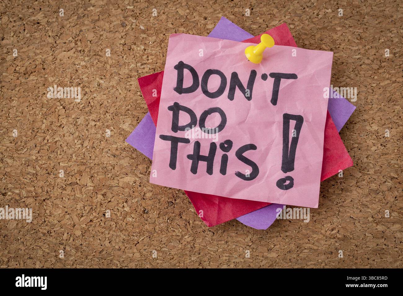 Führen Sie diesen Hinweis oder diese Warnung nicht durch – Handschrift auf rosafarbenen Haftnotizen Stockfoto
