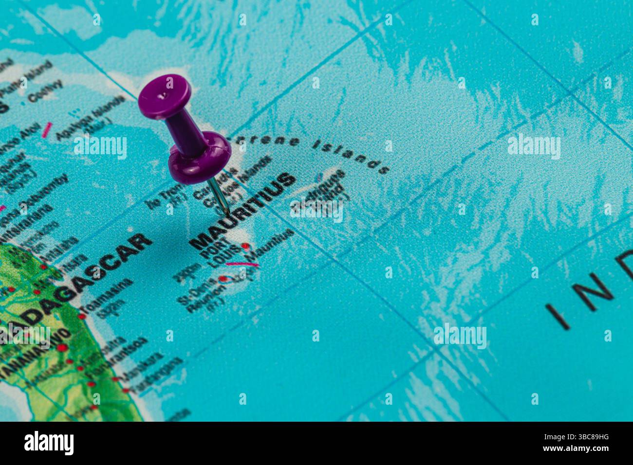 Eine Karte zeigt die Insel Mauritius im Indischen Ozean, hervorgehoben durch eine lila Stecknadel. Die umliegenden Regionen verbessern den geografischen Kontext und Stockfoto