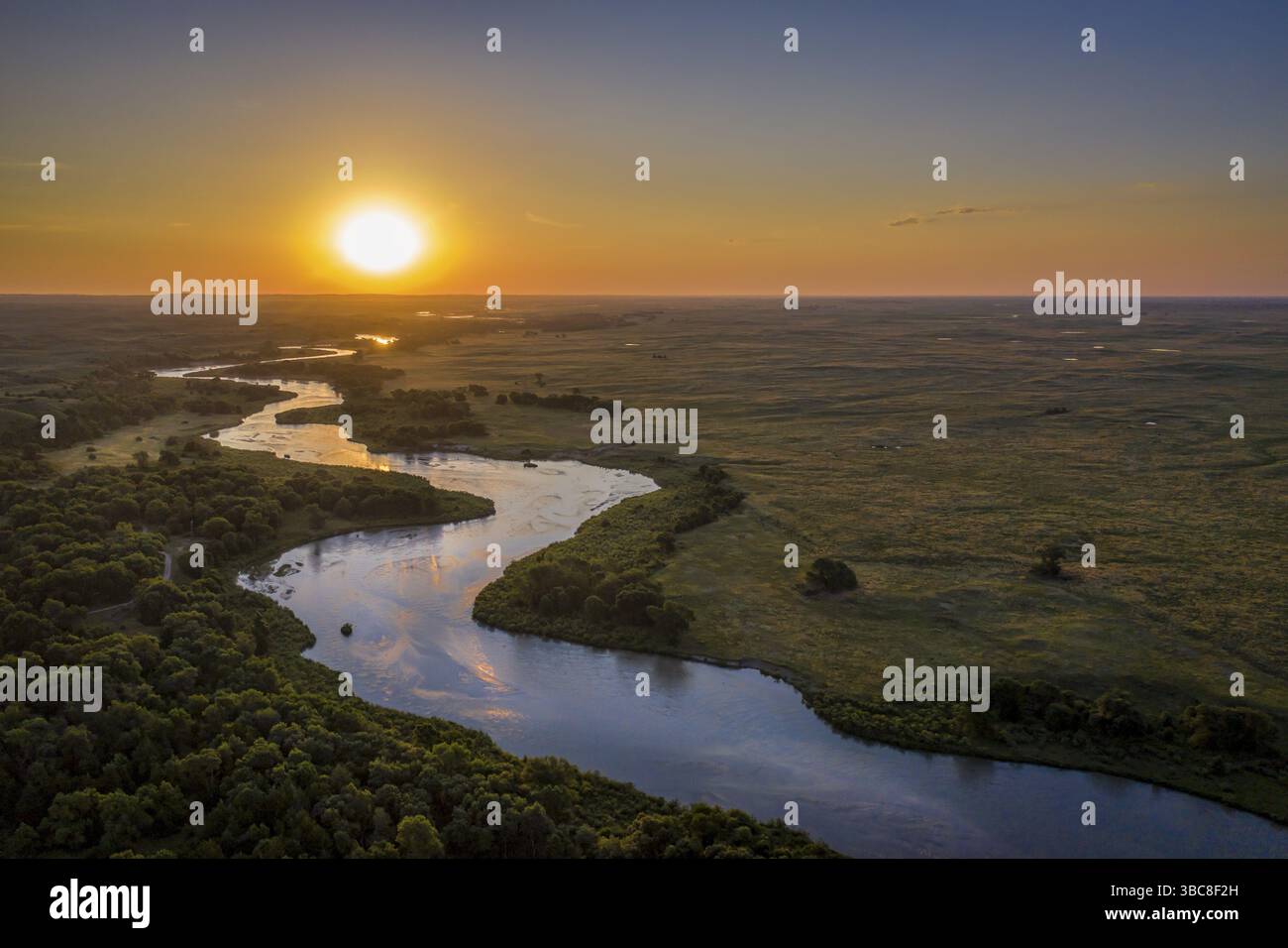 Sonnenaufgang über dem Dismal River schlängelt sich durch die Nebraska Sandhills im Nebraska National Forest, aus der Vogelperspektive auf die Sommerlandschaft Stockfoto