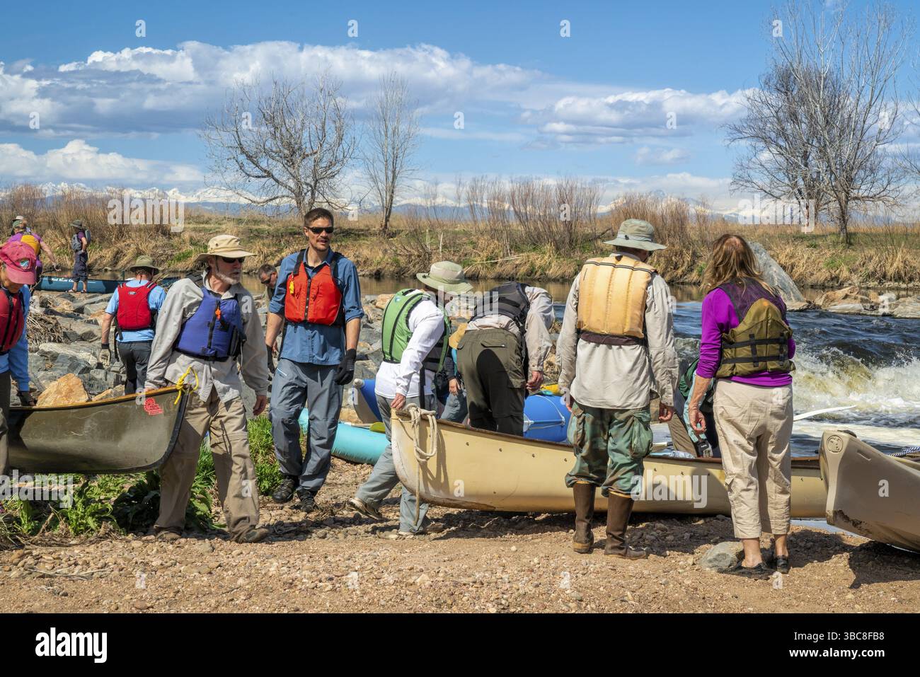 Brighton, CO, USA - 6. April 2019 : Eine Gruppe von Paddlern, die während eines jährlichen Frühlingsausflugs auf dem South Platte River unter Denver Kanus transportieren Stockfoto