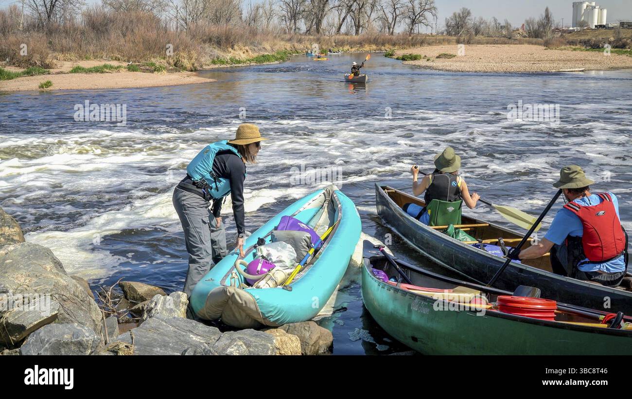 Brighton, CO, USA - 6. April 2019 : Eine Gruppe von Paddlern, die nach einer Reise im Frühjahr auf der South Platte Rive Kajaks und Kanus starten Stockfoto