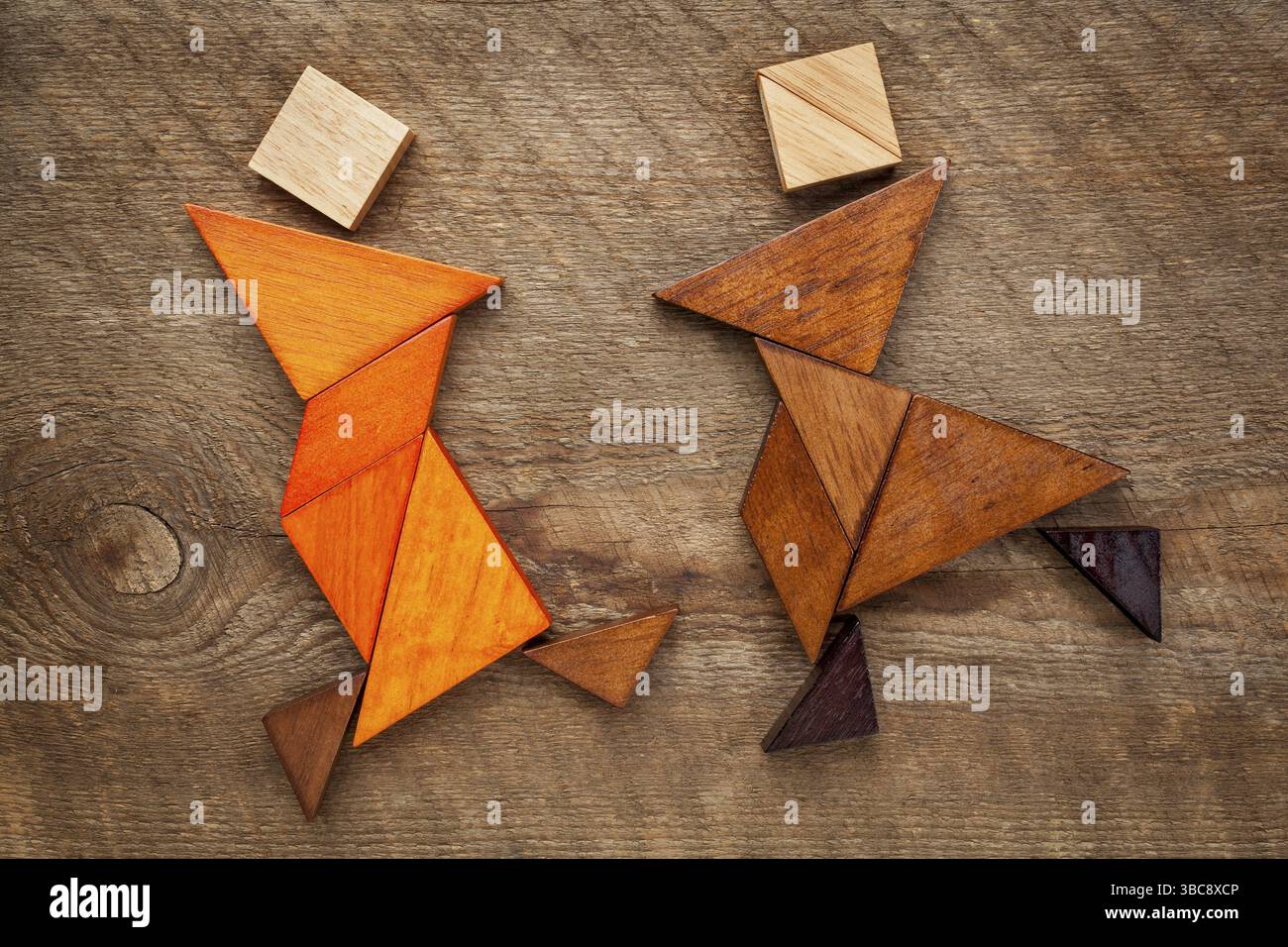 Ein paar Tänzer oder Kampfkünstler - abstrakte Figuren aus Tangram-Holzstücken, ein traditionelles chinesisches Puzzlespiel Stockfoto