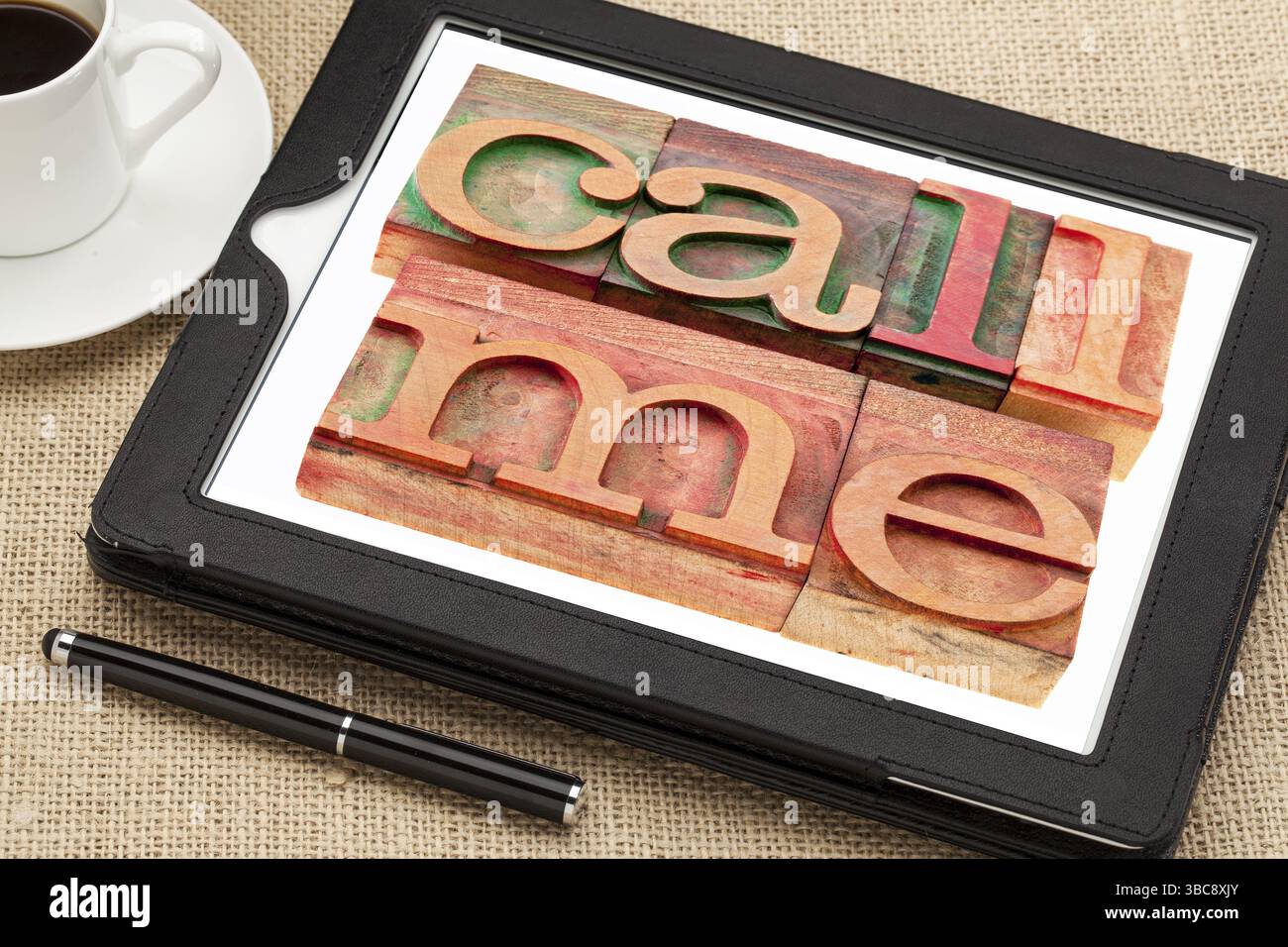 Rufen Sie mich an oder erinnern Sie sich an – Wörter in Vintage-Buchdruckblöcken aus Holz auf einem digitalen Tablet mit einer Tasse Kaffee Stockfoto