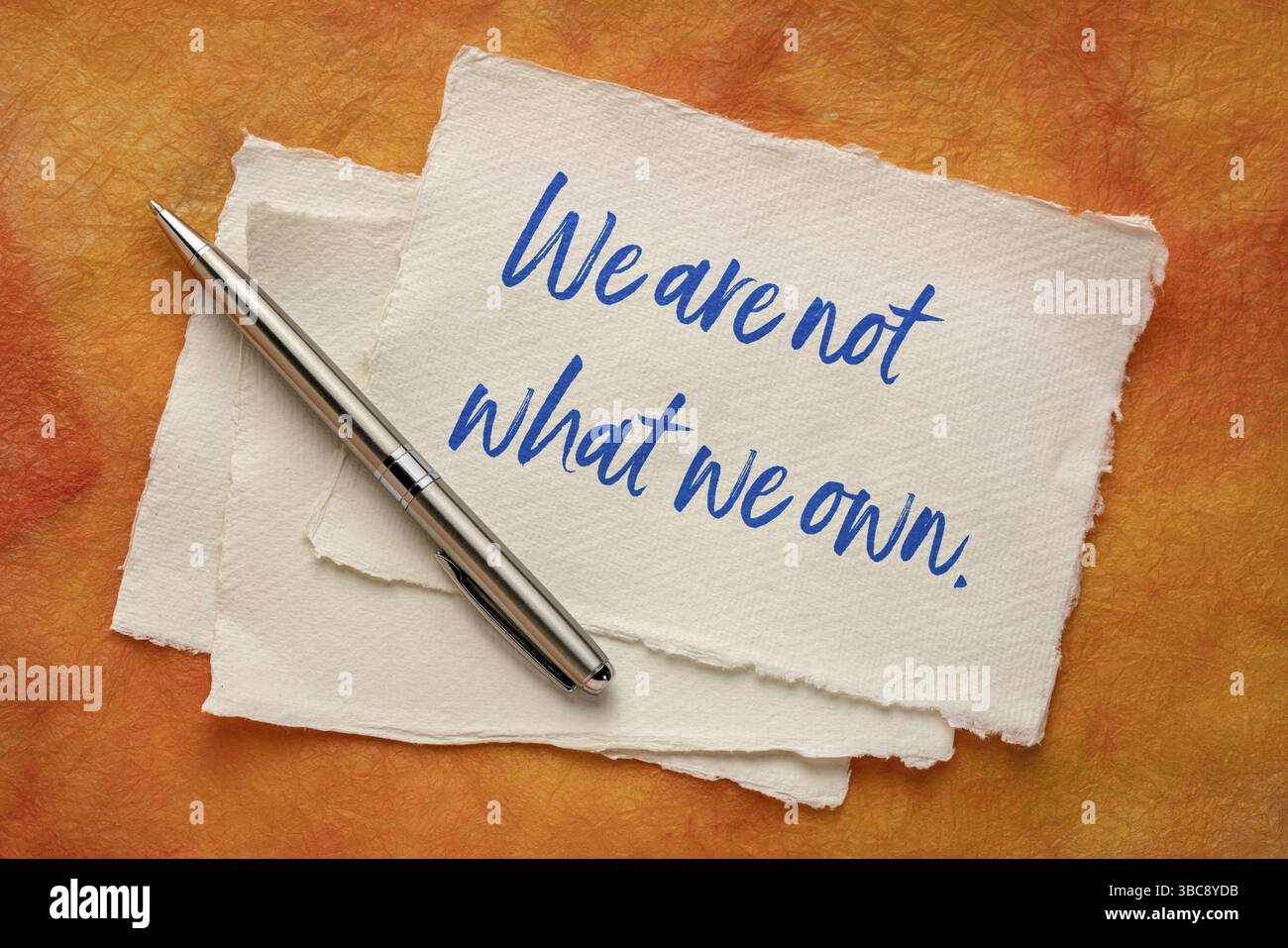 Wir sind nicht das, was wir besitzen - inspirational Handschrift auf handgeschöpftem Papier, Einfachheit, Minimalismus, Lebensstil und Konsum Konzept Stockfoto