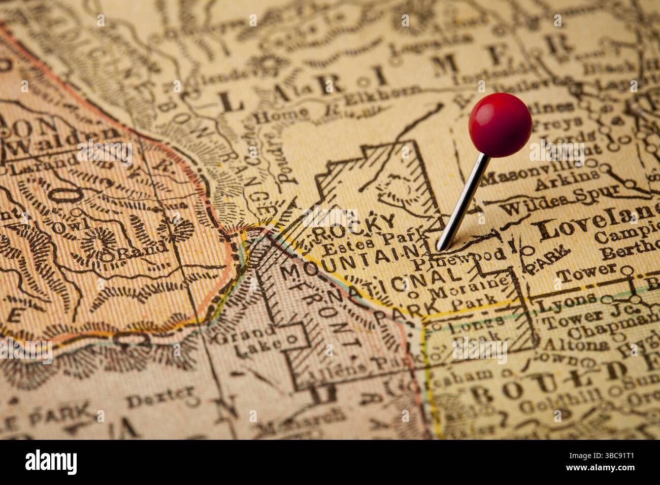 Rocky Mountain Nationalpark auf Vintage 1920er Jahre Karte von Colorado mit einem roten Pin auf Osten Eintrag in Estes Park, selektiven Fokus Stockfoto