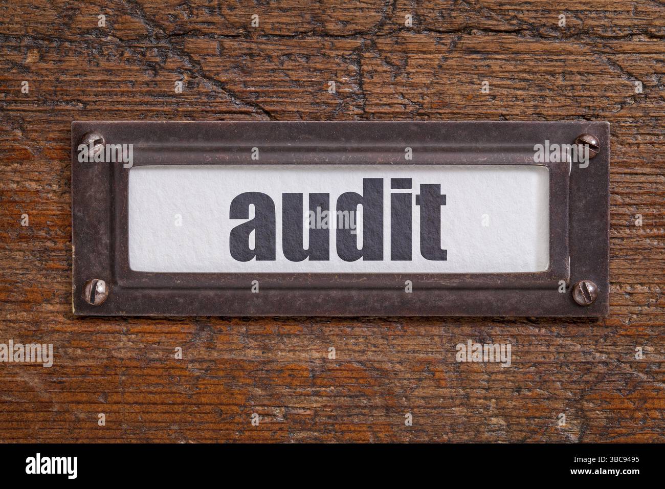 Audit – Aktenschranketikett, Bronzehalter gegen Schmirgeln und verkratztes Holz Stockfoto