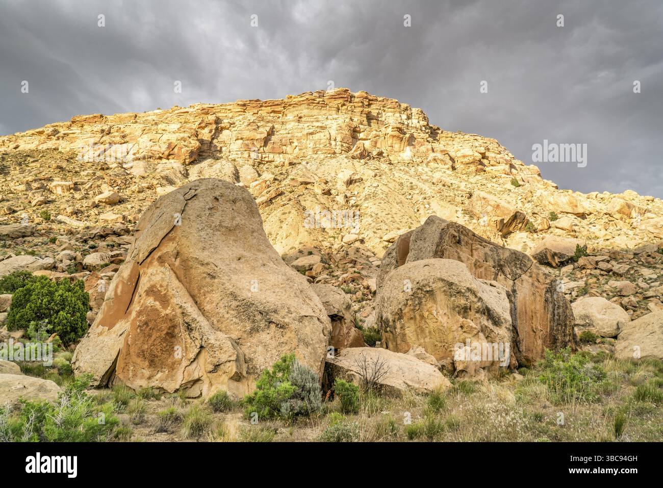 Buchen Sie Klippen unter stürmischen Wolken - Wüstenlandschaft des östlichen Utah mit einem Felsen und Geröll Stockfoto