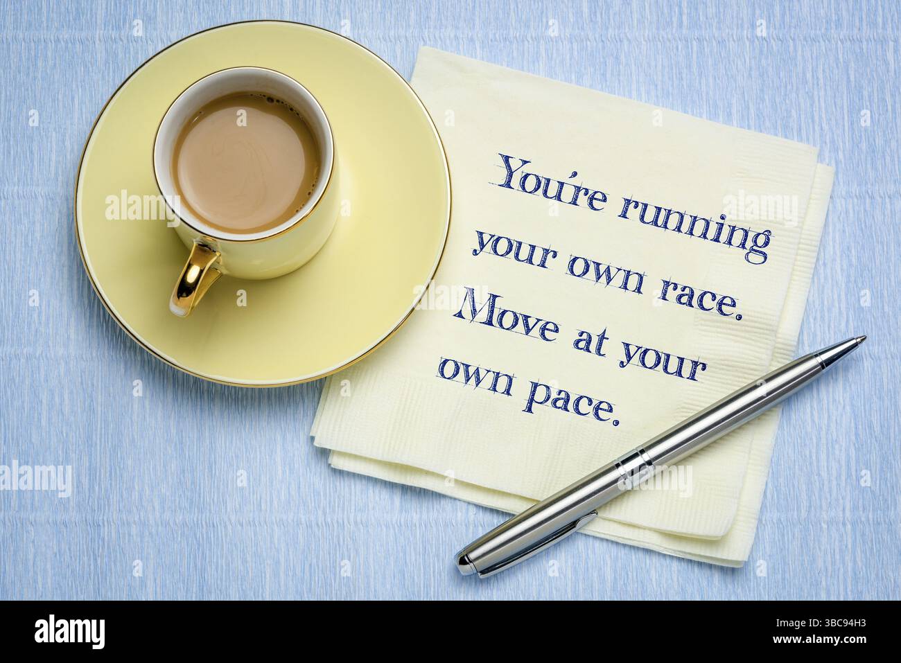 Du führst dein eigenes Rennen. Bewege dich in deinem eigenen Poace. Inspirierende Handschrift auf einer Serviette mit einer Tasse Kaffee Stockfoto