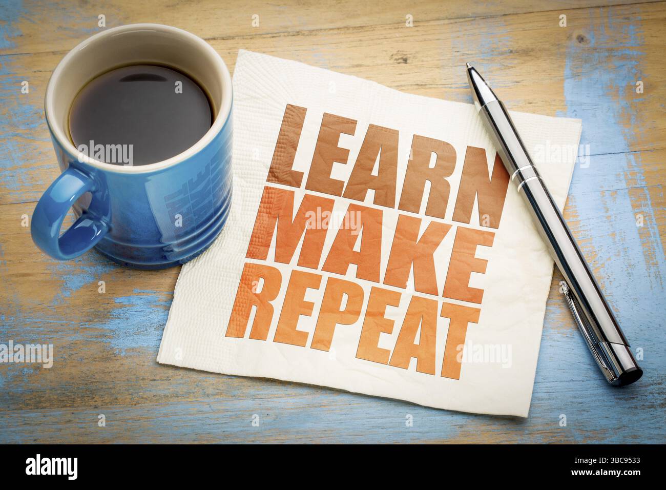 Lernen Sie, machen Sie ein wiederholtes Motivationskonzept auf einer Serviette mit einer Tasse Kaffee Stockfoto